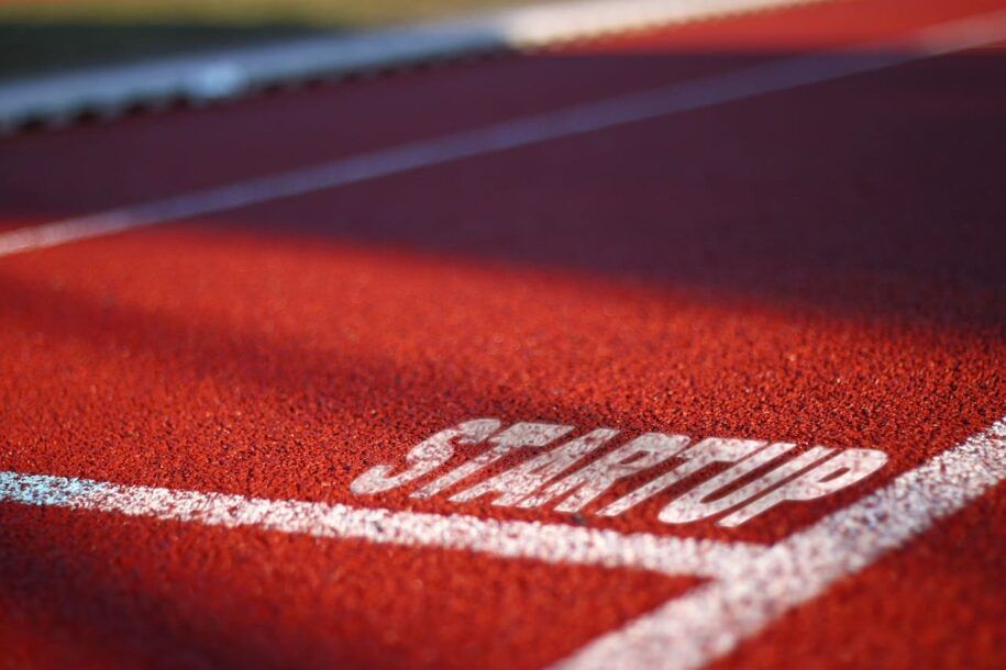 foto de pista de atletismo en color rojo, con texto STARTUP serigrafiado en blanco